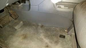 Kick panel at the bottom of the center console, driver's side