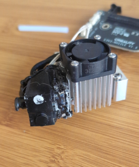 Entombed 3D printer hotend encased in black PLA plastic